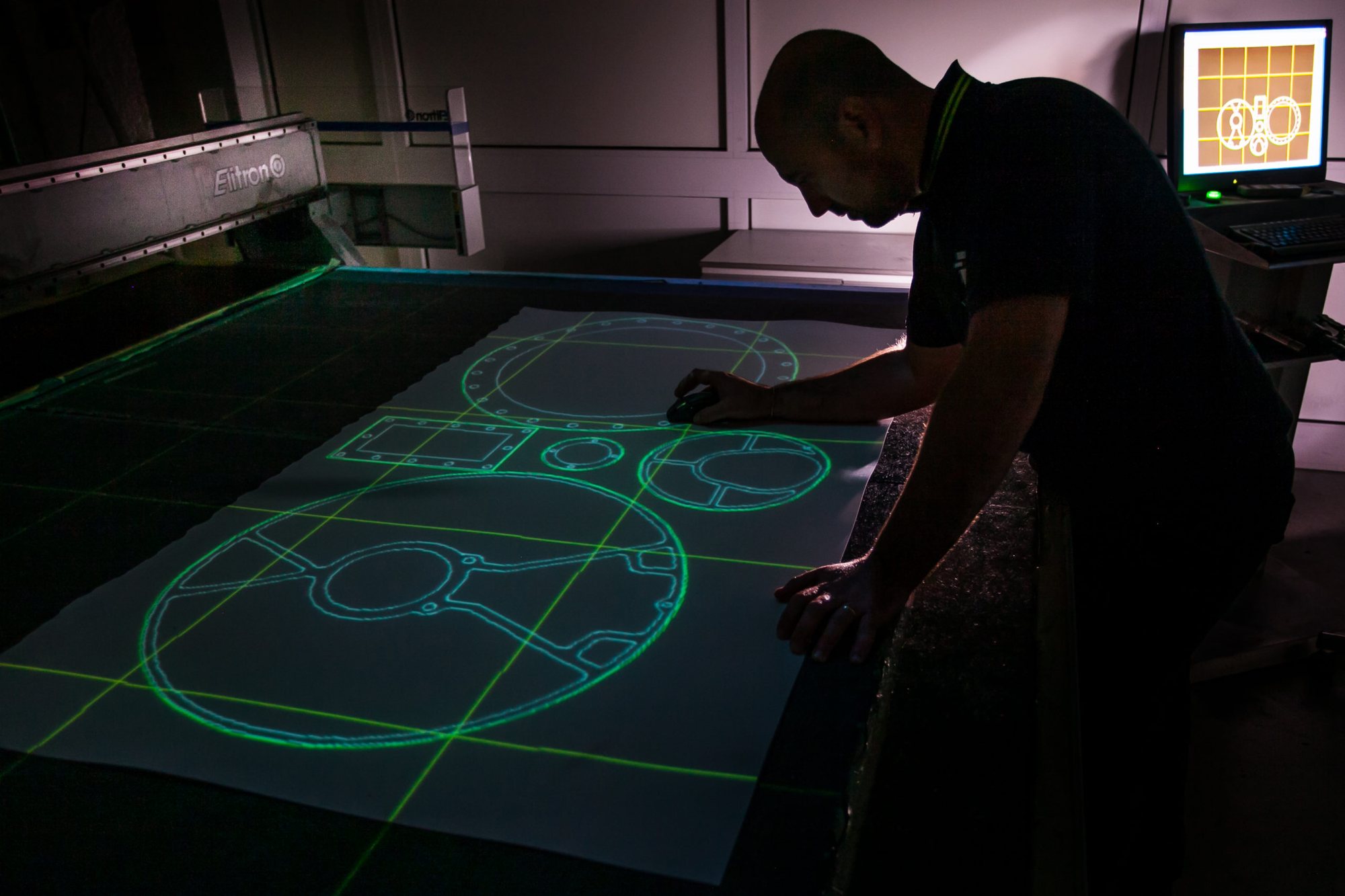 Operatore GGS al plotter di taglio con proiezione laser del disegno tecnico delle guarnizioni